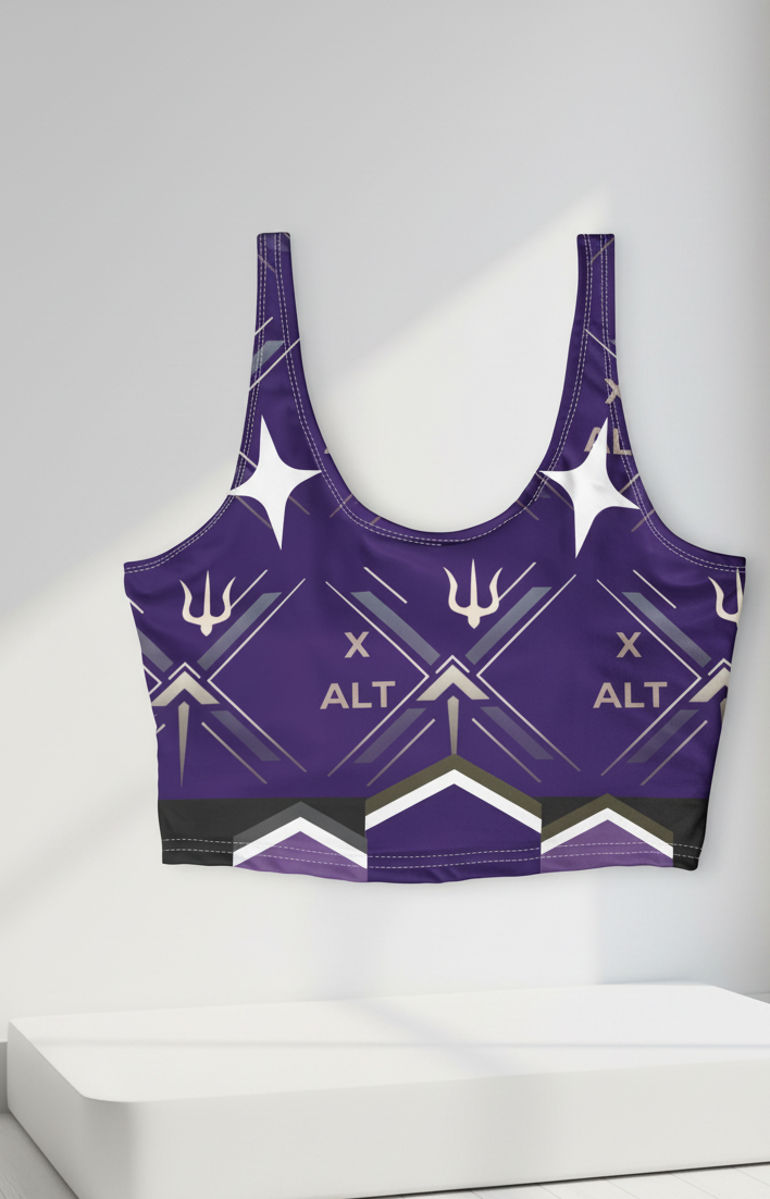 A purple sports bra with a geometric pattern featuring white and black details, the word 'XALT' printed on the front, and a stylized trident symbol, displayed on a white pedestal against a light gray background.
